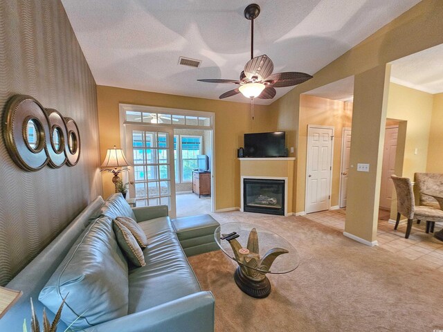 carpeted living room with ceiling fan and a textured ceiling