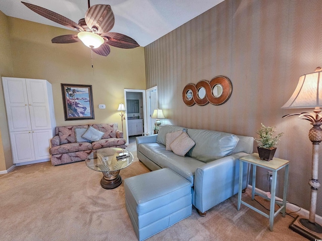 living room with ceiling fan, light carpet, and a towering ceiling