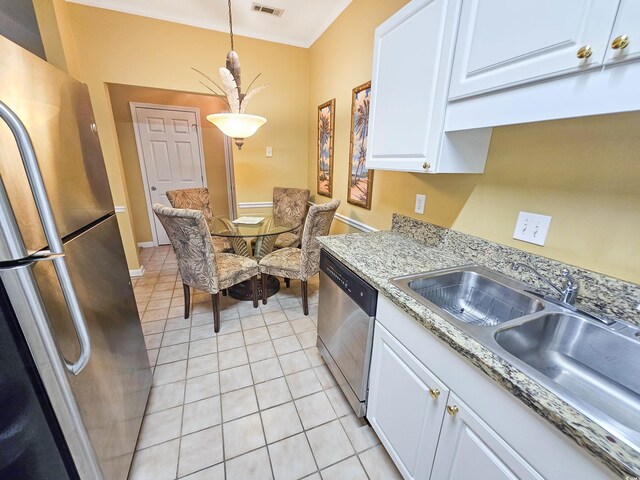 kitchen with light tile patterned floors, light stone counters, stainless steel appliances, white cabinetry, and sink