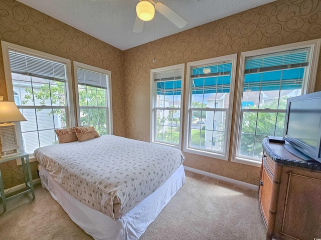 carpeted bedroom with ceiling fan and a textured ceiling