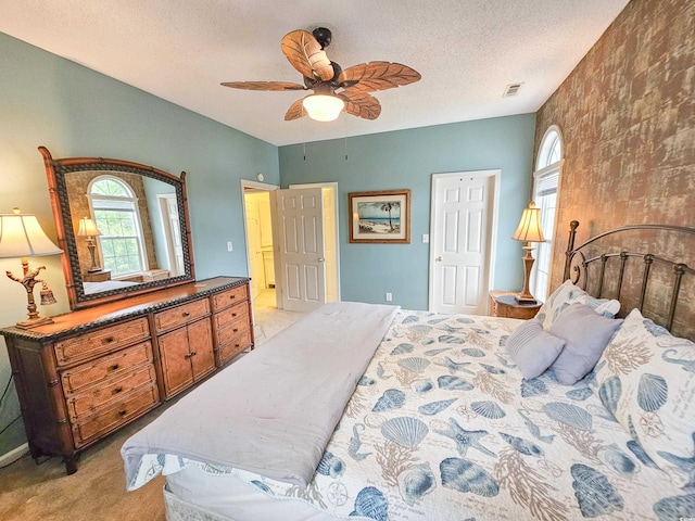 carpeted bedroom featuring ceiling fan and a textured ceiling