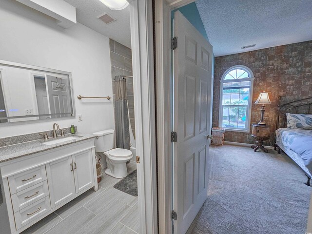 bathroom featuring a shower with curtain, toilet, a textured ceiling, and vanity