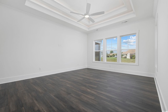 empty room with dark wood-type flooring, a raised ceiling, ceiling fan, and crown molding