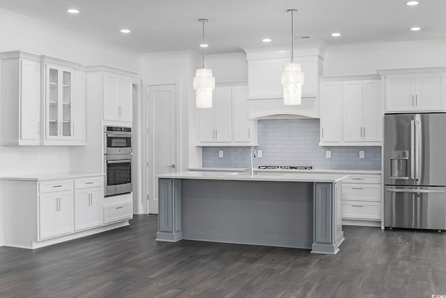 kitchen with dark hardwood / wood-style floors, an island with sink, decorative light fixtures, white cabinets, and appliances with stainless steel finishes