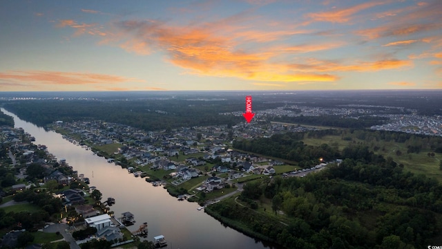 aerial view at dusk featuring a water view