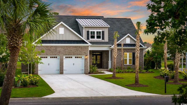 craftsman house featuring board and batten siding, a front lawn, driveway, and a standing seam roof