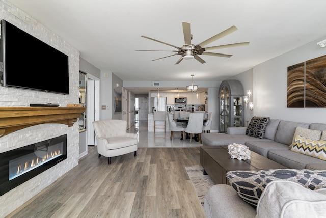 living room with ceiling fan, a fireplace, and hardwood / wood-style floors