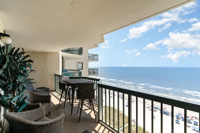 balcony with a water view and a beach view