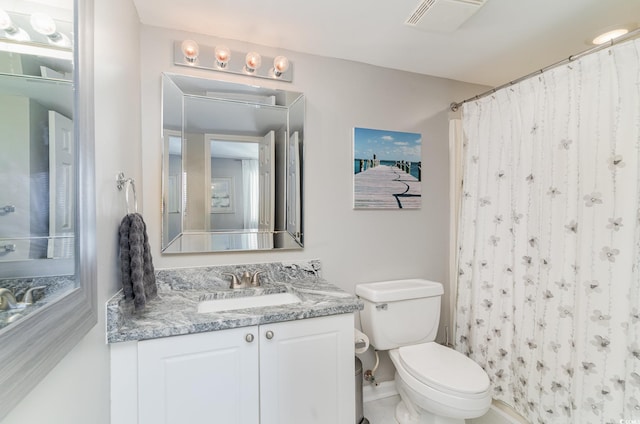 bathroom with toilet, vanity, and tile patterned flooring