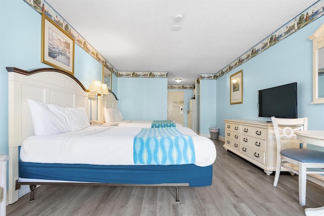 bedroom with wood-type flooring and a textured ceiling