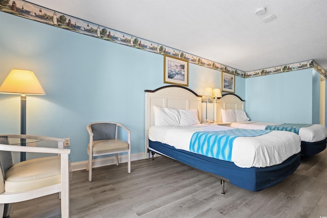 bedroom with hardwood / wood-style flooring and a textured ceiling