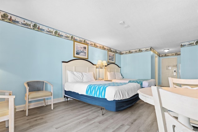 bedroom with light hardwood / wood-style flooring and a textured ceiling