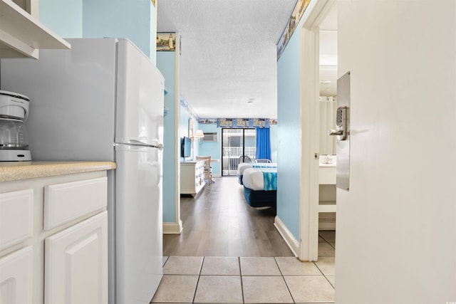 hallway with light tile patterned floors and a textured ceiling