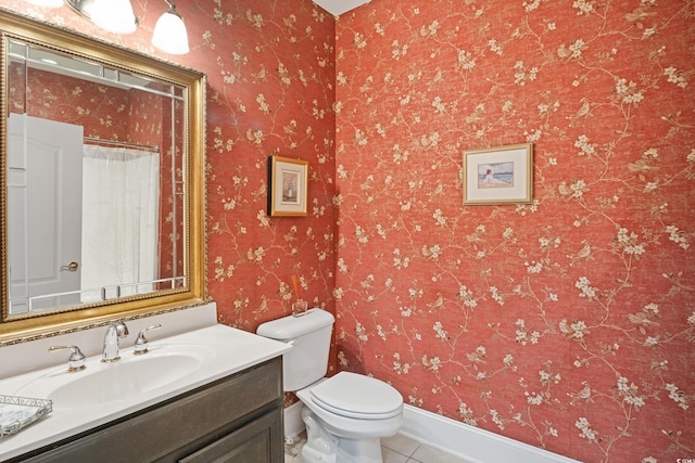 bathroom with tile patterned flooring, vanity, and toilet