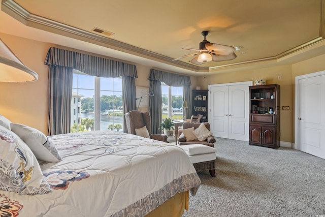 bedroom with carpet, ceiling fan, and a raised ceiling