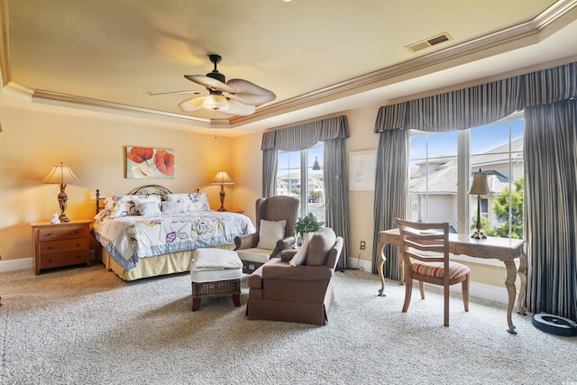 carpeted bedroom with ceiling fan, a raised ceiling, and crown molding