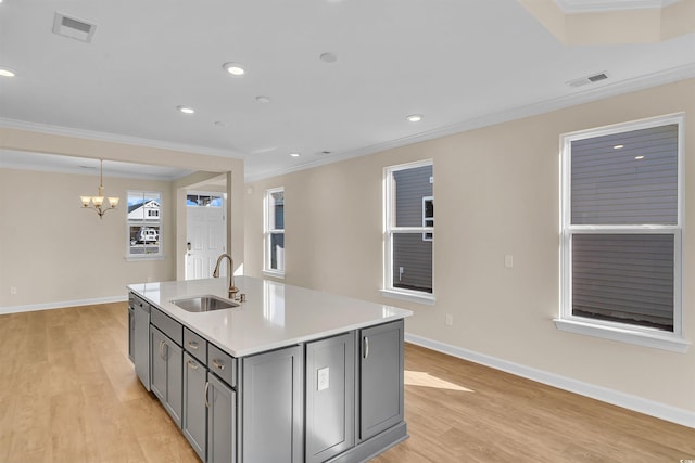 kitchen featuring gray cabinetry, crown molding, sink, and an inviting chandelier