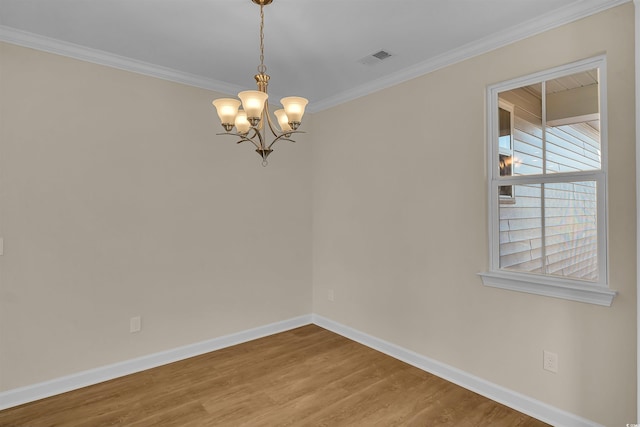 empty room with wood-type flooring, ornamental molding, and a chandelier