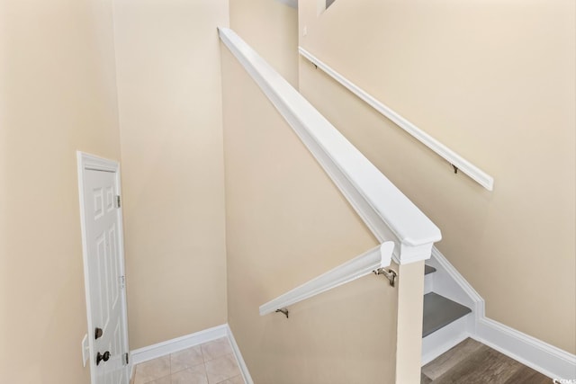 stairs with tile patterned floors and baseboards
