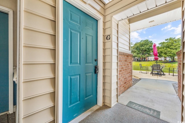 property entrance with brick siding and covered porch