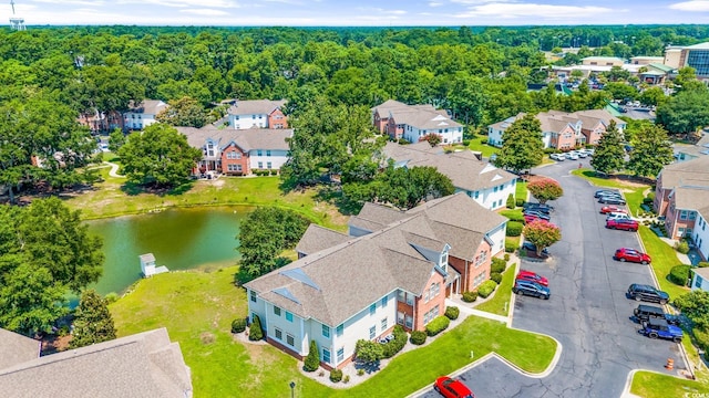 drone / aerial view featuring a water view, a view of trees, and a residential view