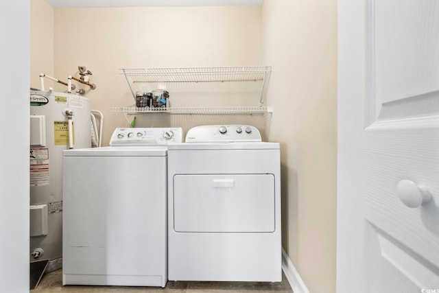 laundry room with water heater, baseboards, separate washer and dryer, and laundry area