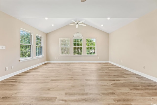 spare room featuring baseboards, a ceiling fan, light wood-style floors, and lofted ceiling