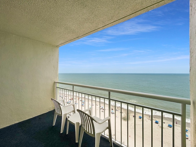 balcony with a water view and a beach view