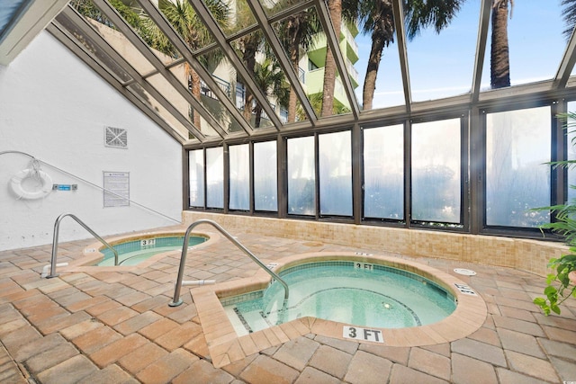 view of swimming pool with a patio and an indoor hot tub