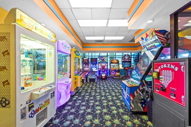 game room featuring a paneled ceiling and dark colored carpet