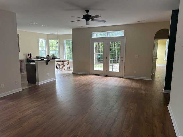 unfurnished living room with ceiling fan and dark wood-type flooring