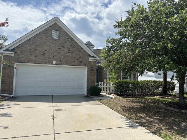 view of front of house featuring brick siding, concrete driveway, and a garage