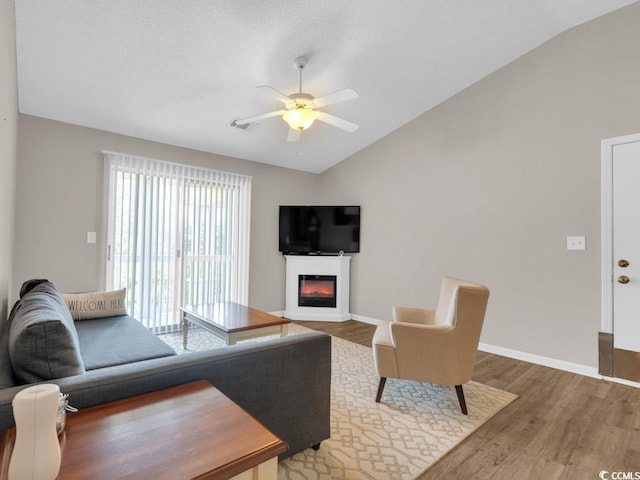 living room with lofted ceiling, hardwood / wood-style floors, and ceiling fan