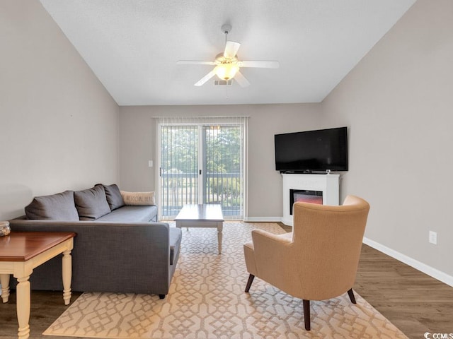 living room featuring lofted ceiling, ceiling fan, and hardwood / wood-style flooring