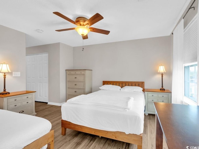 bedroom with hardwood / wood-style floors, ceiling fan, and a closet