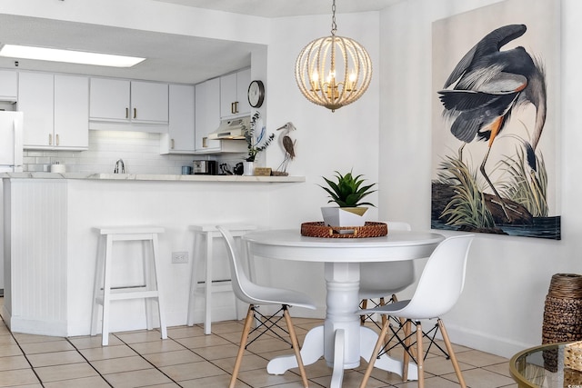 dining area featuring a notable chandelier, baseboards, and light tile patterned floors