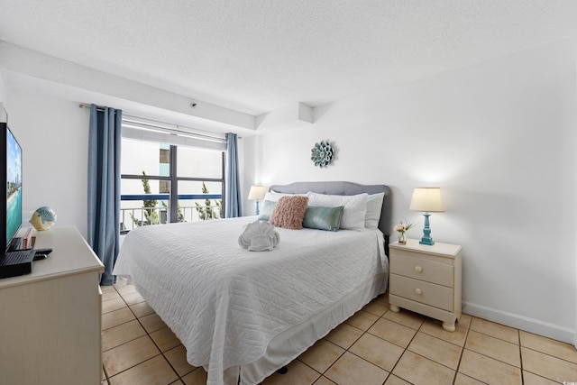 bedroom with baseboards, a textured ceiling, and light tile patterned flooring