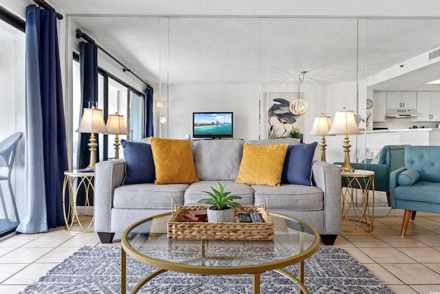 living area with light tile patterned floors, visible vents, a textured ceiling, and an inviting chandelier