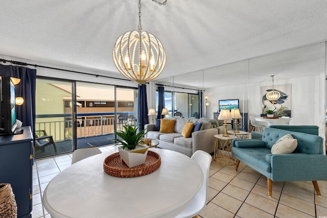 dining area with light tile patterned flooring, a textured ceiling, and an inviting chandelier