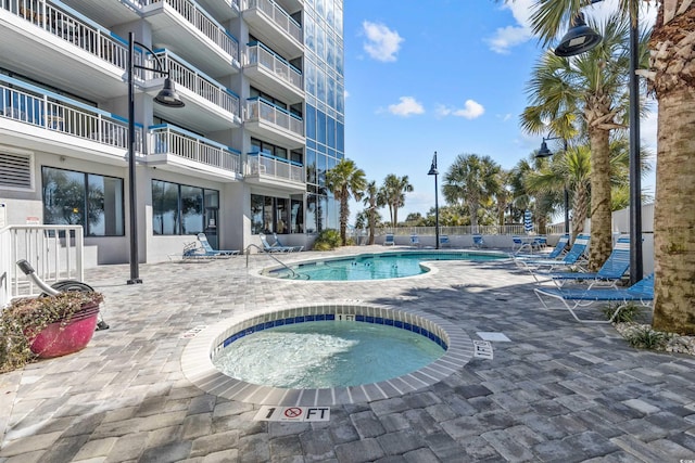 community pool featuring a patio area and a community hot tub