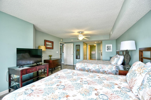 bedroom featuring ceiling fan, wood-type flooring, and a textured ceiling