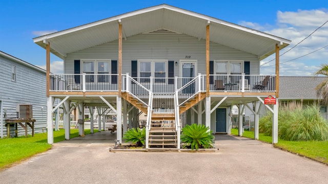 coastal inspired home with a porch and a carport