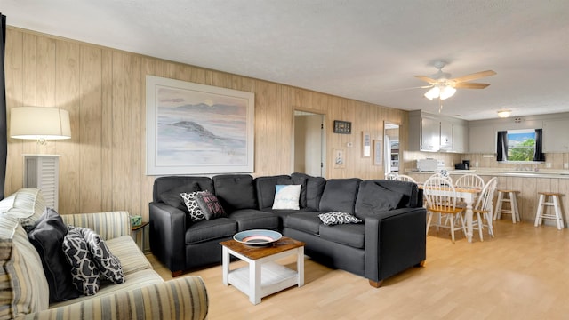 living room with light hardwood / wood-style floors and ceiling fan