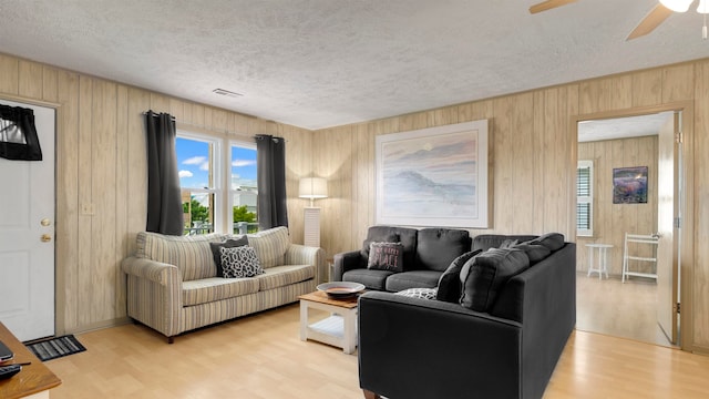 living room with light wood-type flooring and a textured ceiling