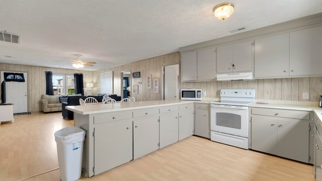 kitchen featuring kitchen peninsula, light hardwood / wood-style floors, white appliances, and ceiling fan