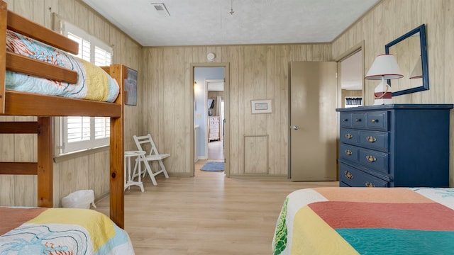 bedroom featuring wood walls and light wood-type flooring