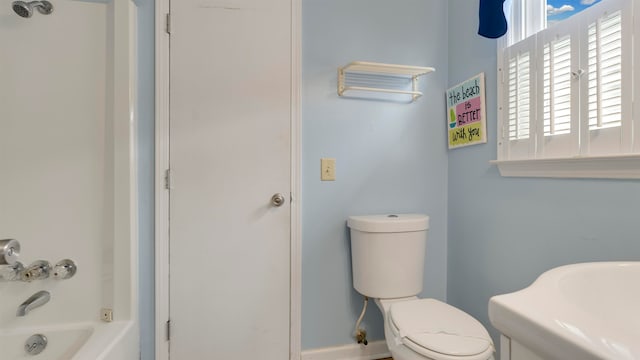 bathroom with bathing tub / shower combination and toilet