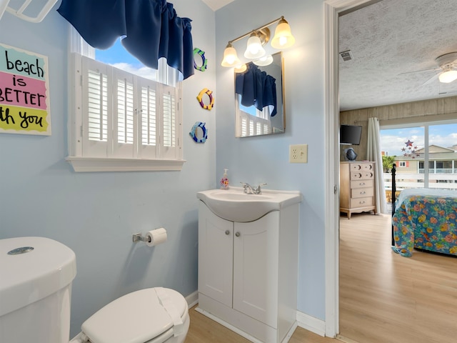 bathroom with vanity, toilet, hardwood / wood-style flooring, and plenty of natural light