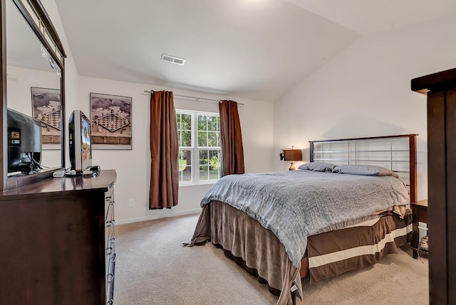 bedroom with vaulted ceiling and light colored carpet