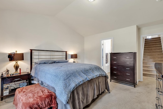 bedroom featuring light carpet, connected bathroom, and vaulted ceiling